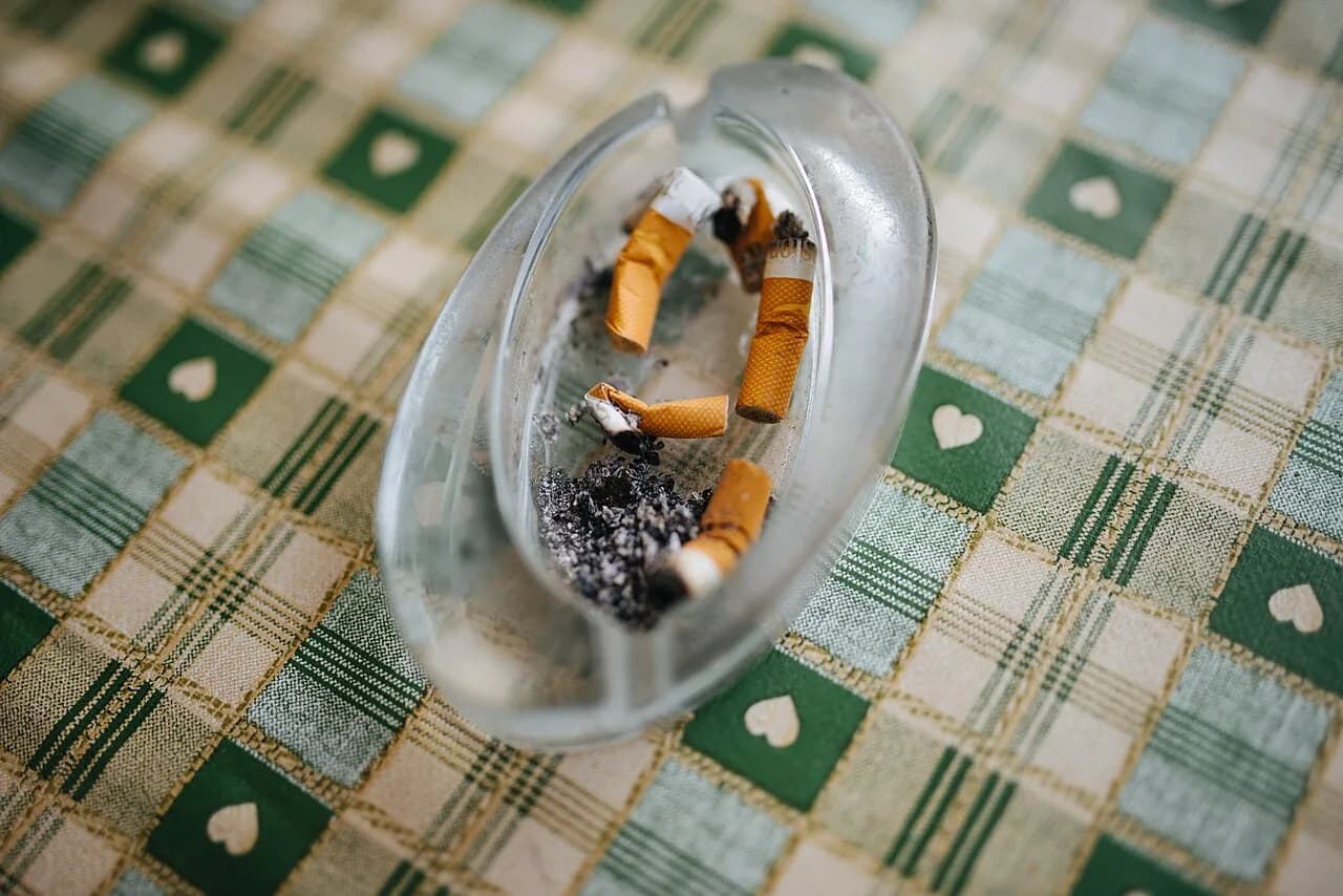 An ashtray holding used cigarette butts sits